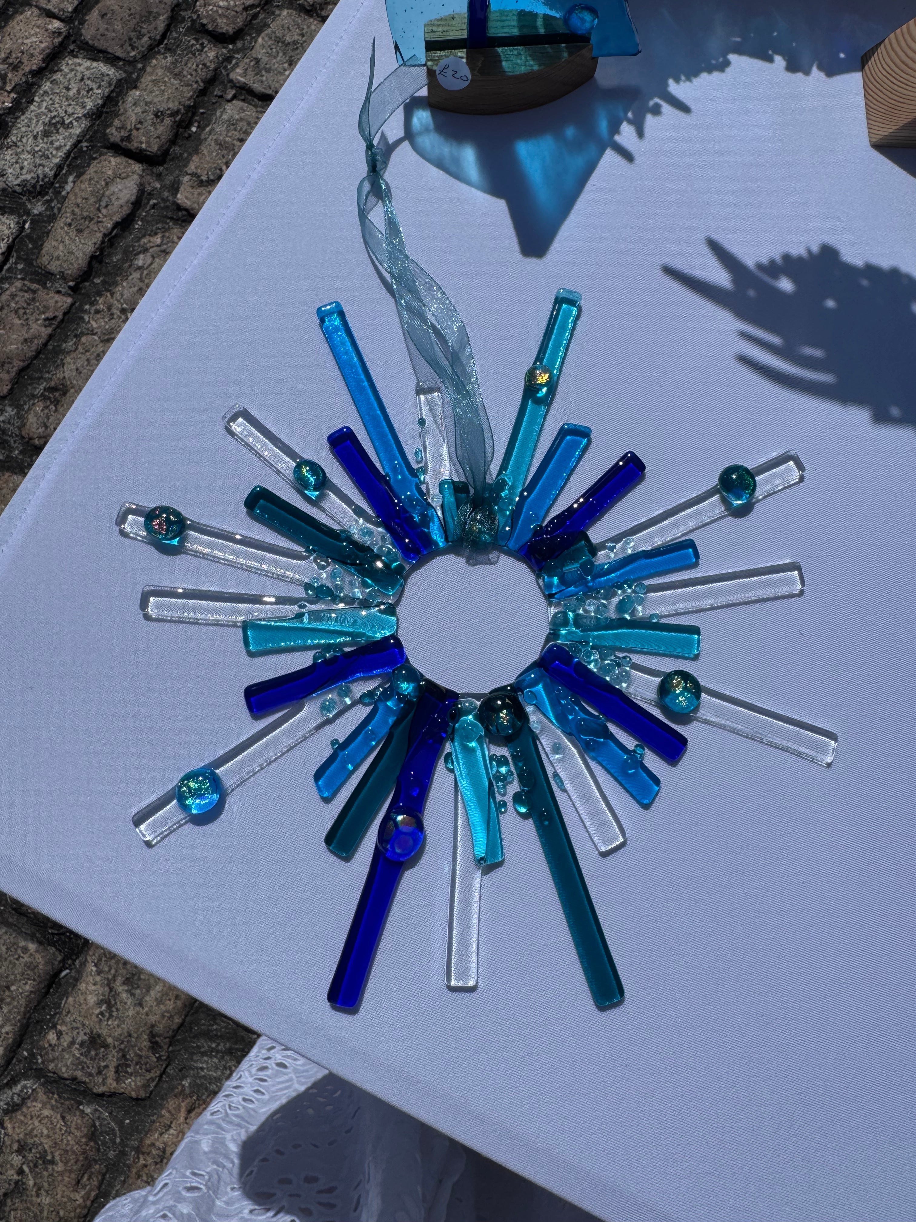 Handmade blue starburst fused glass suncatcher with cobalt, teal and clear glass rods