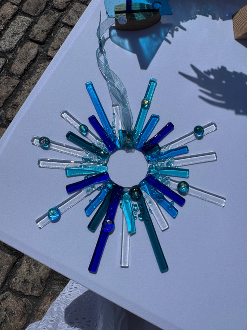 Handmade blue starburst fused glass suncatcher with cobalt, teal and clear glass rods